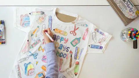 Girl drawing 100 days of school shirt with fabric markers