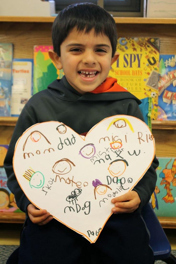 boy holding valentines heart sign