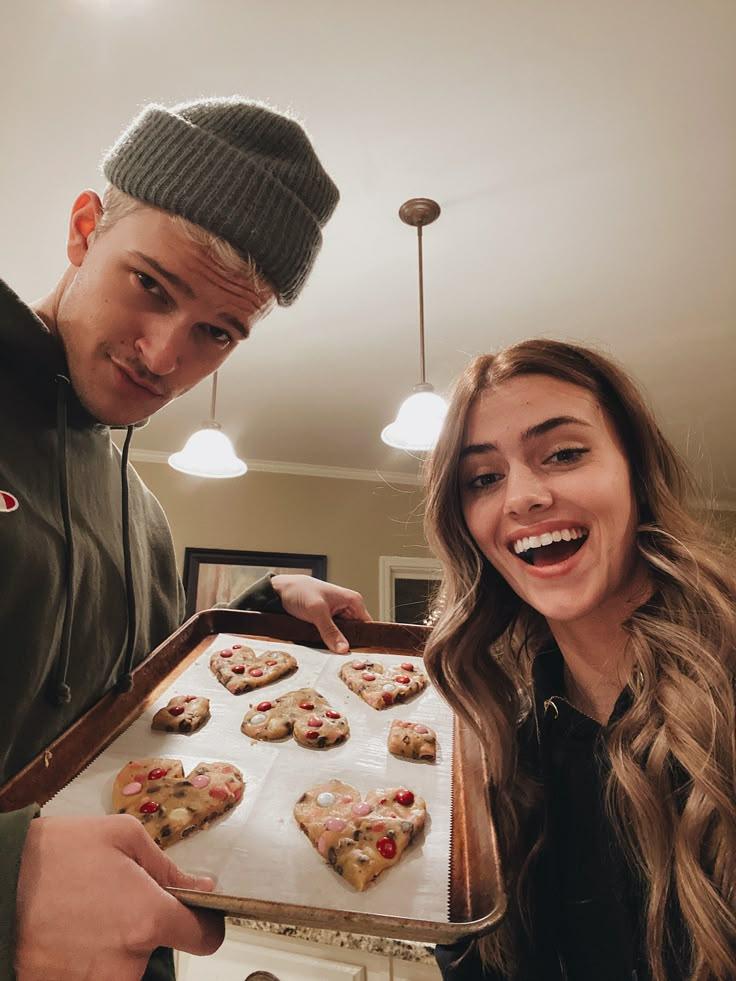 couple wearing matching thanksgiving shirts in kitchen preparing food