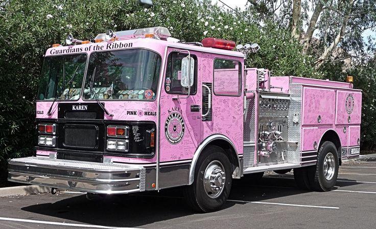 A group of firefighters wearing pink firefighter breast cancer shirts.