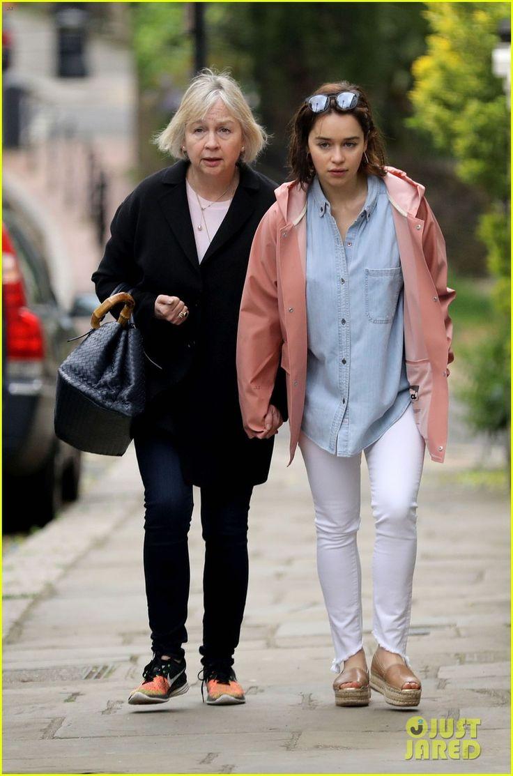 Mum and daughter walking down street wearing matching grey hoodies and jeans.