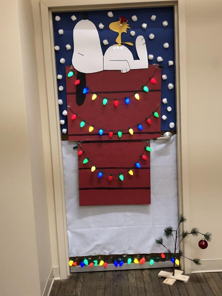 Snoopy and Woodstock decorating a Christmas tree with lights